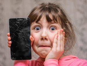 Child holding a broken phone